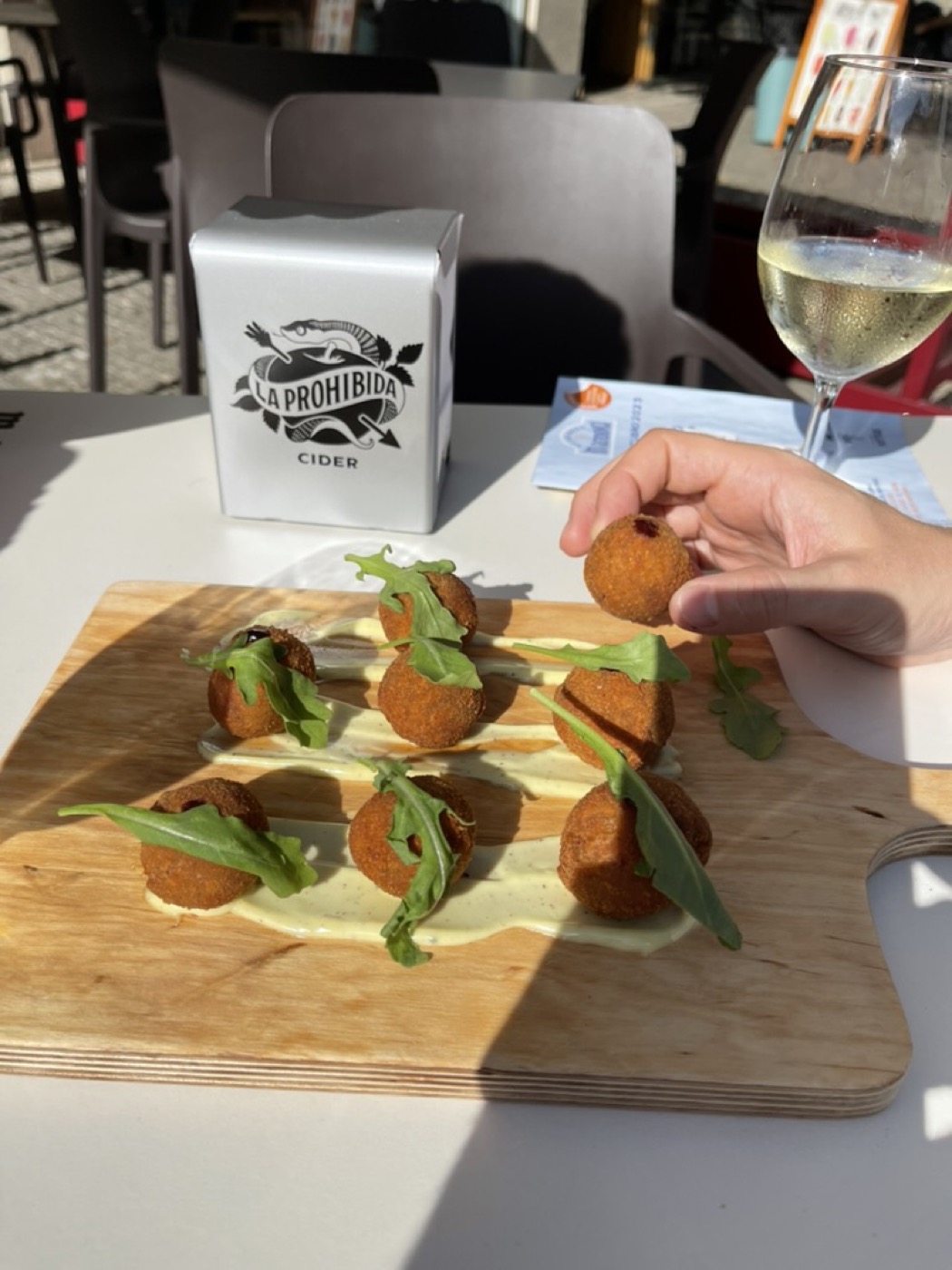 A wooden board of croquettes with salad garnish, one of the Rally Fish tapas stops
